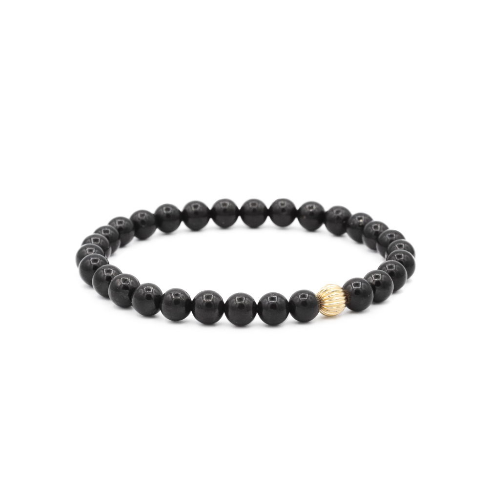 a black beaded bracelet with gold accents