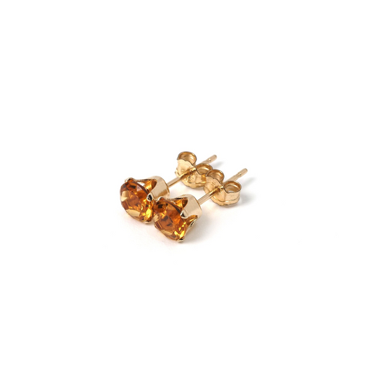 a pair of yellow gold earrings on a white background