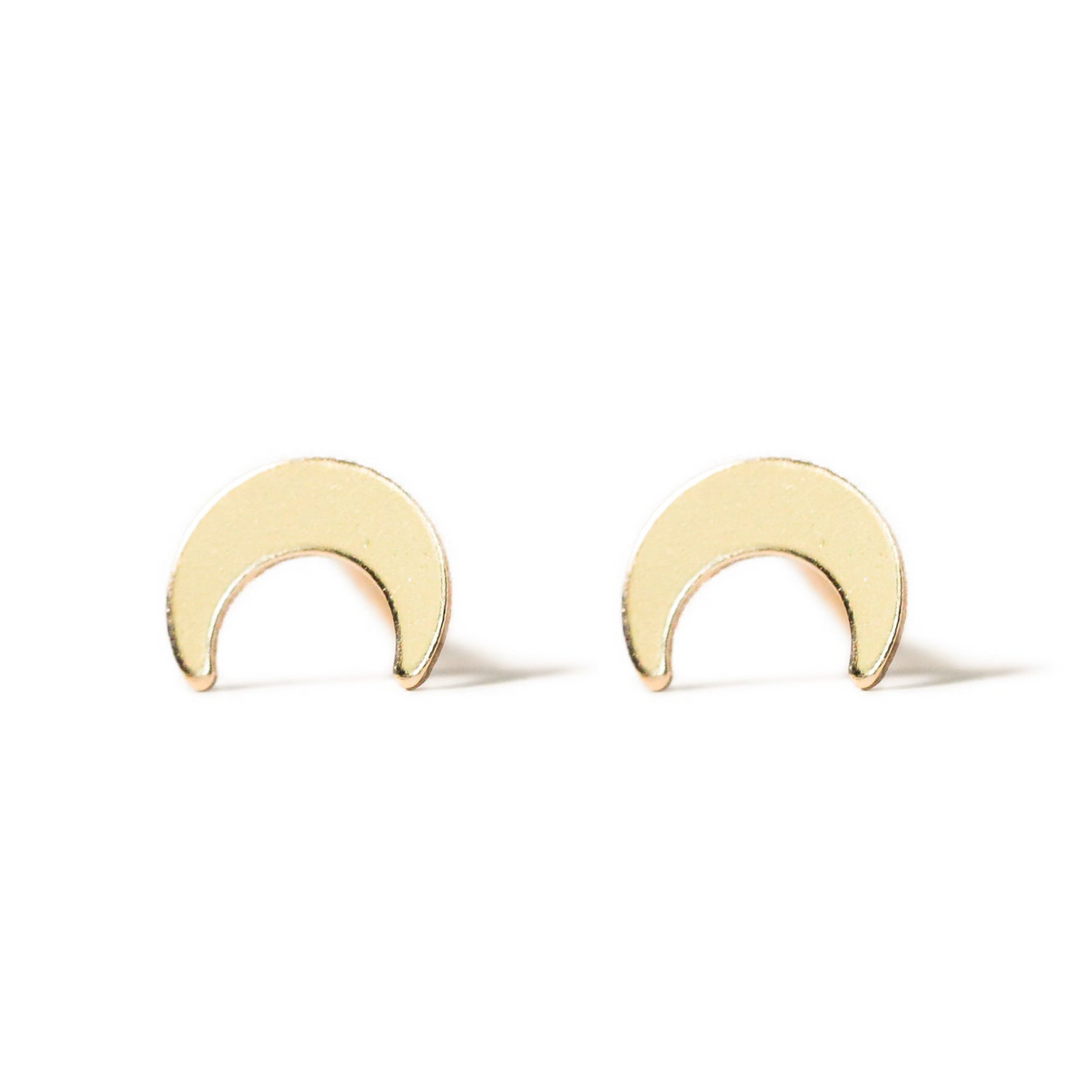 a pair of gold earrings with a crescent design